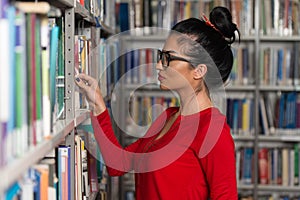 Happy Female Student With Book In Library