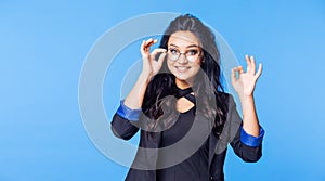 Happy female student with glasses and a black jacket showing thumbs up OK