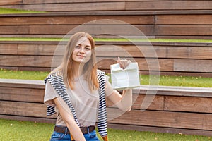 Happy female student holding a paper bag