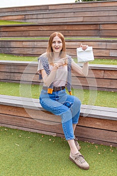 Happy female student holding a paper bag