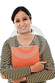 Happy female student holding text book