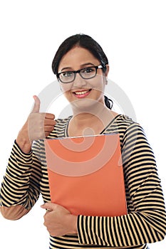 Happy female student holding text book