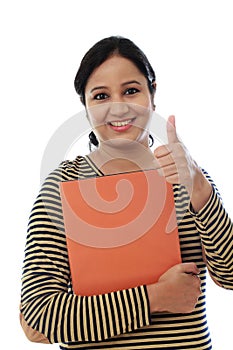Happy female student holding text book
