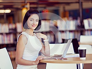 Happy female student at the library