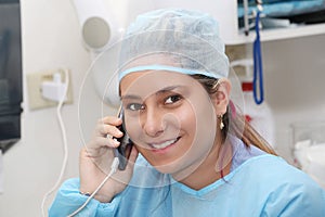 Happy female surgeon using mobile phone