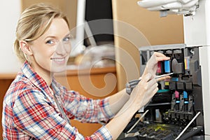 happy female technician fixing printer