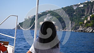 Happy female tourist in sunglasses cruising on vessel, enjoys boat trip, sailing on ship in Mediterranean sea, traveling