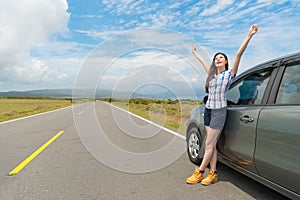 Happy female traveler standing on asphalt road