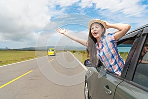 Happy female traveler stuck out car window
