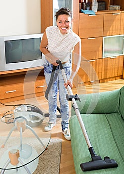 Happy female with vacuum cleaner smiling