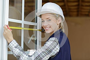 happy female worker measures window