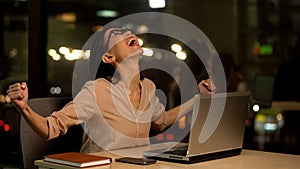 Happy female worker showing success gesture, startup promotion, achievement