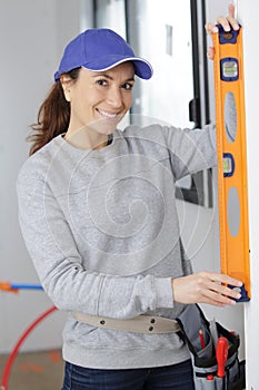 happy female worker woman with level on white