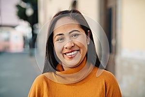 Happy filipina woman having fun smiling in front of camera in the city