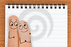 Happy Finger Face Couple with Blank Notepad Copy Space