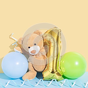 Happy first birthday or anniversary card with teddy bear and balloons. Gold number one