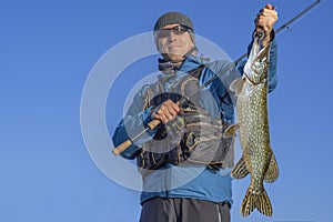 Happy fisherman with big pike fish trophy