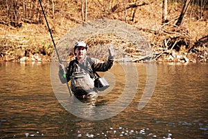 Happy fisherman holding a grayling caught