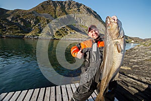 Happy fisherman showing thumb. The huge fish. The horizontal position