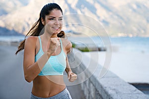 Happy fit fitness woman exercising, running outdoors to stay healthy.