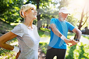 Happy fit senior couple exercising in park