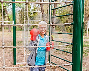 Happy Fit Senior Woman With Boxing Glove At Outdoor Gym