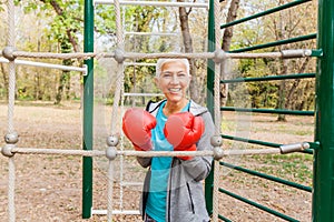 Happy Fit Senior Woman With Boxing Glove At Outdoor Gym