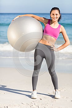 Happy fit woman holding exercise ball