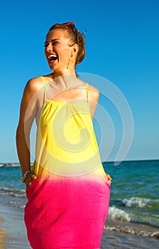 Happy fit woman on seacoast in evening looking aside