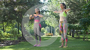 Happy fit women doing pilates training in park