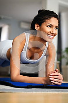 Happy fit young woman exercising at home. Healthy lifestyle, people, sport concept