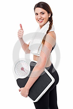 Happy Fitness woman with a weighing scale