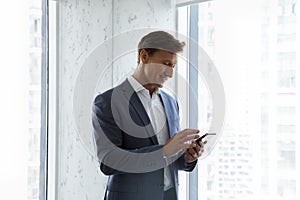 Happy focused business man using virtual app on smartphone