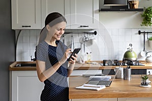 Happy focused gadget user girl browsing Internet on mobile phone