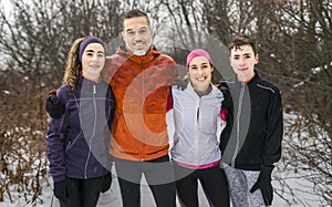 Happy four family jogging in winter forest
