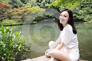 A happy free smile peace balance meditation beauty girl Asian Chinese travel hiking smell maple do yoga by lake bag hangzhou xihu