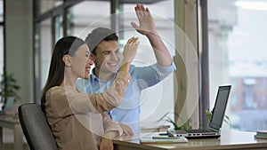 Happy freelancers monitoring company ratings online giving high five and smiling