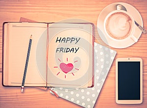 Happy Friday on notebook , pencil, smart phone and coffee cup