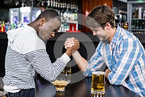 Happy friend arm wrestling each other