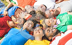 Happy friend group lying on meadow after world soccer event - Fr