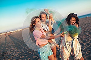 Happy friend walking on beautiful beach in summer sunset in their hands is smoke fontain