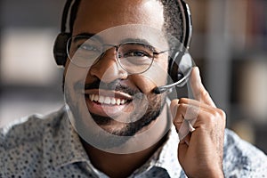 Happy friendly african telemarketing operator wear wireless headset portrait