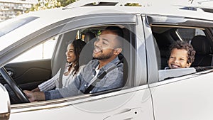 Happy friendly black family riding car traveling by automobile