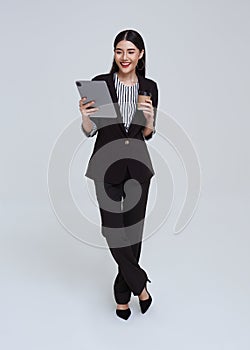 Happy and friendly face asian businesswoman entrepreneur smile in formal suit her using tablet on white background studio shot