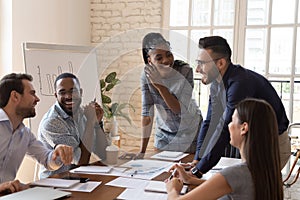 Happy friendly multiracial team laughing working together at corporate briefing