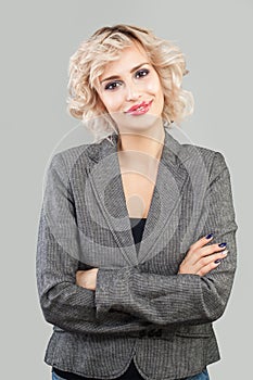 Happy friendly woman smiling and standing with crossed arms portrait. Smart businesswoman in suit portrait