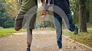Happy friends Arabian people Indian couple man woman in city park outdoors standing on one leg try balance stretching