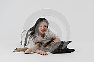 Happy friends. Beauty woman and shepherd dog looks at camera embracing together in studio. Cut out on white background