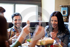 Happy friends with beer eating at bar or pub