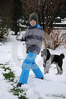 Happy friends, boy and dog ,playing in the in snow